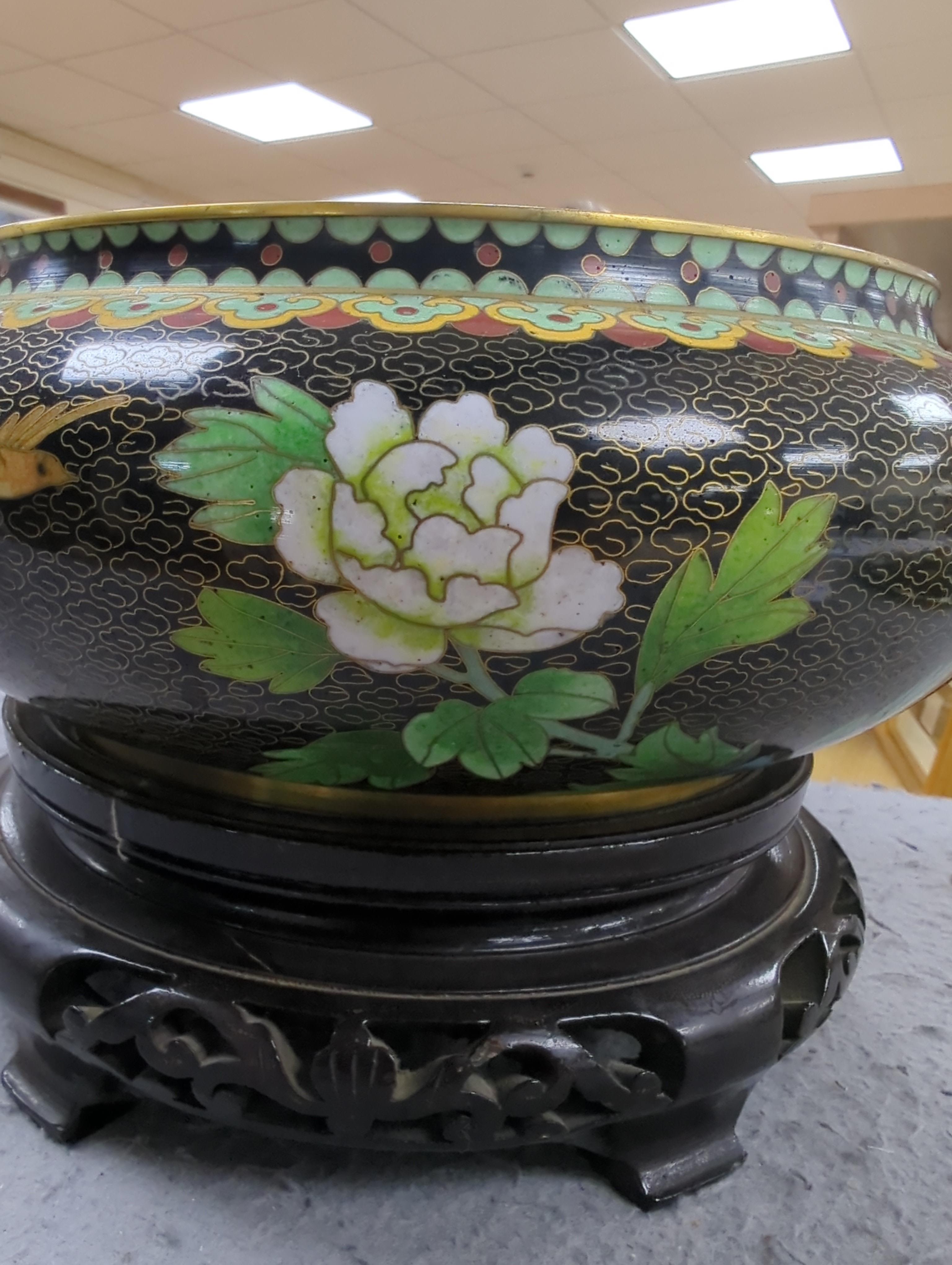 A Chinese cloisonné enamel three footed vase and cover together with a censer and cover, each raised on hardwood stands, the largest 26cm in diameter